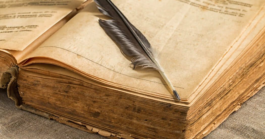 Un libro antiguo abierto con una pluma